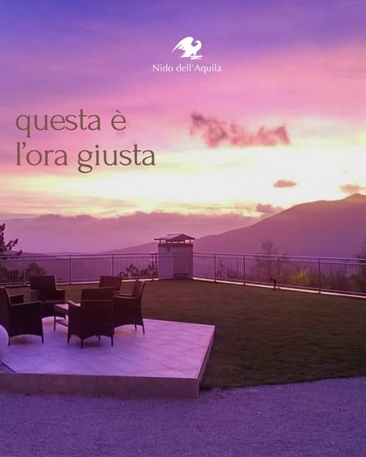 tramonto viola sulla terrazza con le poltroncine e la scritta questa è l'ora giusta